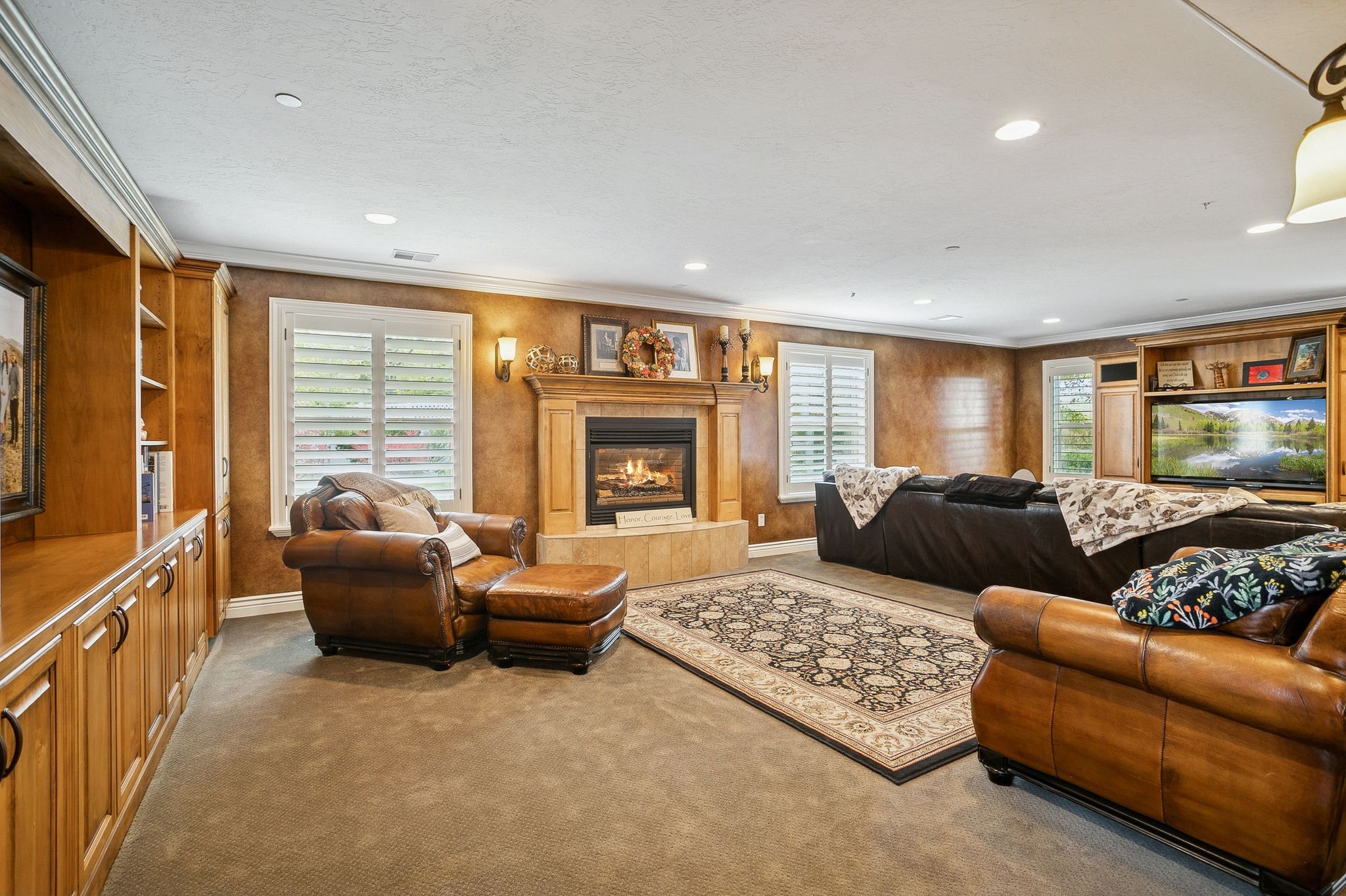 Carpeted living area featuring plenty of natural light, crown molding, a tile fireplace, and recessed lighting