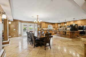 Dining room with french doors, light tile patterned flooring, and a chandelier