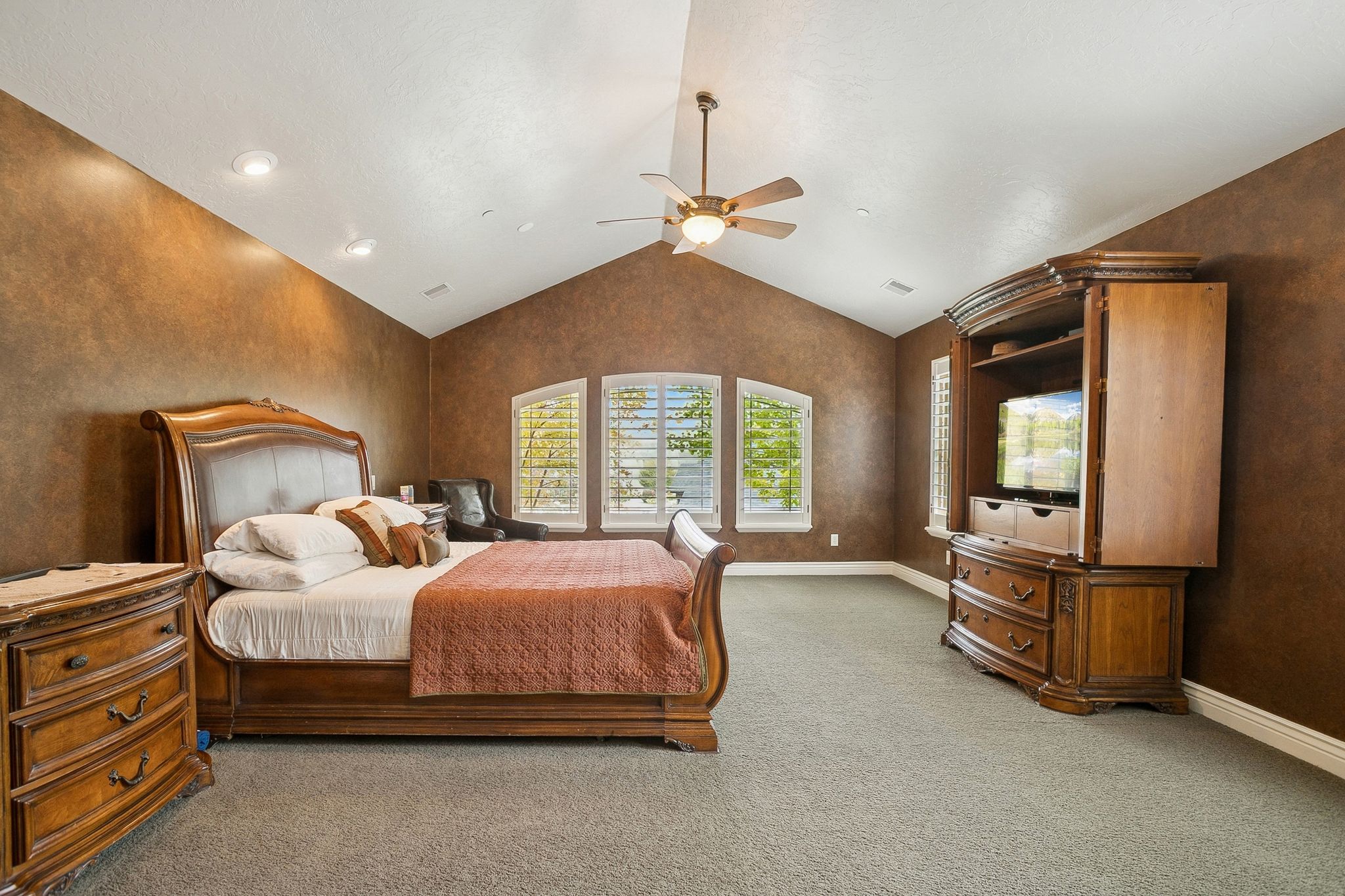 Bedroom with carpet, lofted ceiling, a ceiling fan, and a textured wall