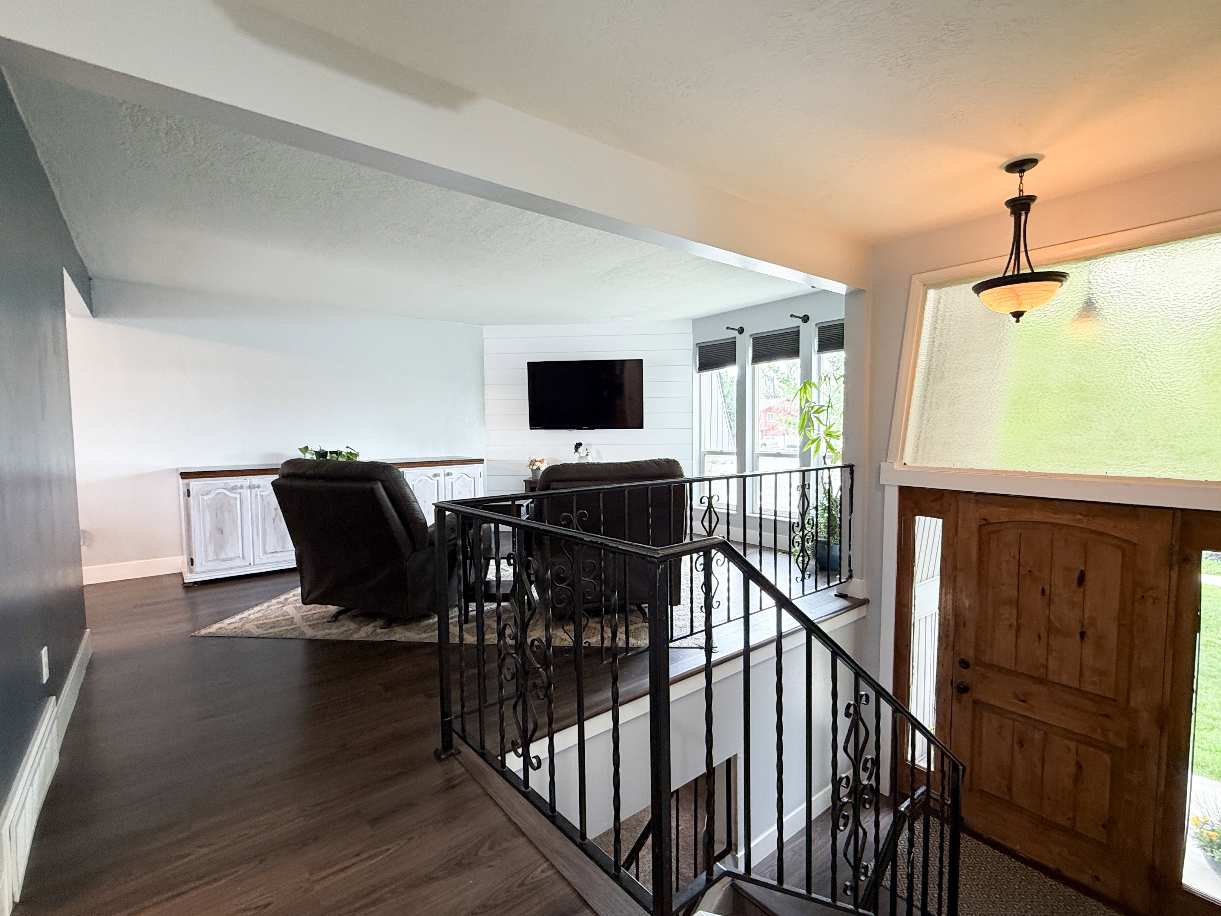 Hardwood flooring extends throughout the main living area, complemented by a white shiplap accent wall