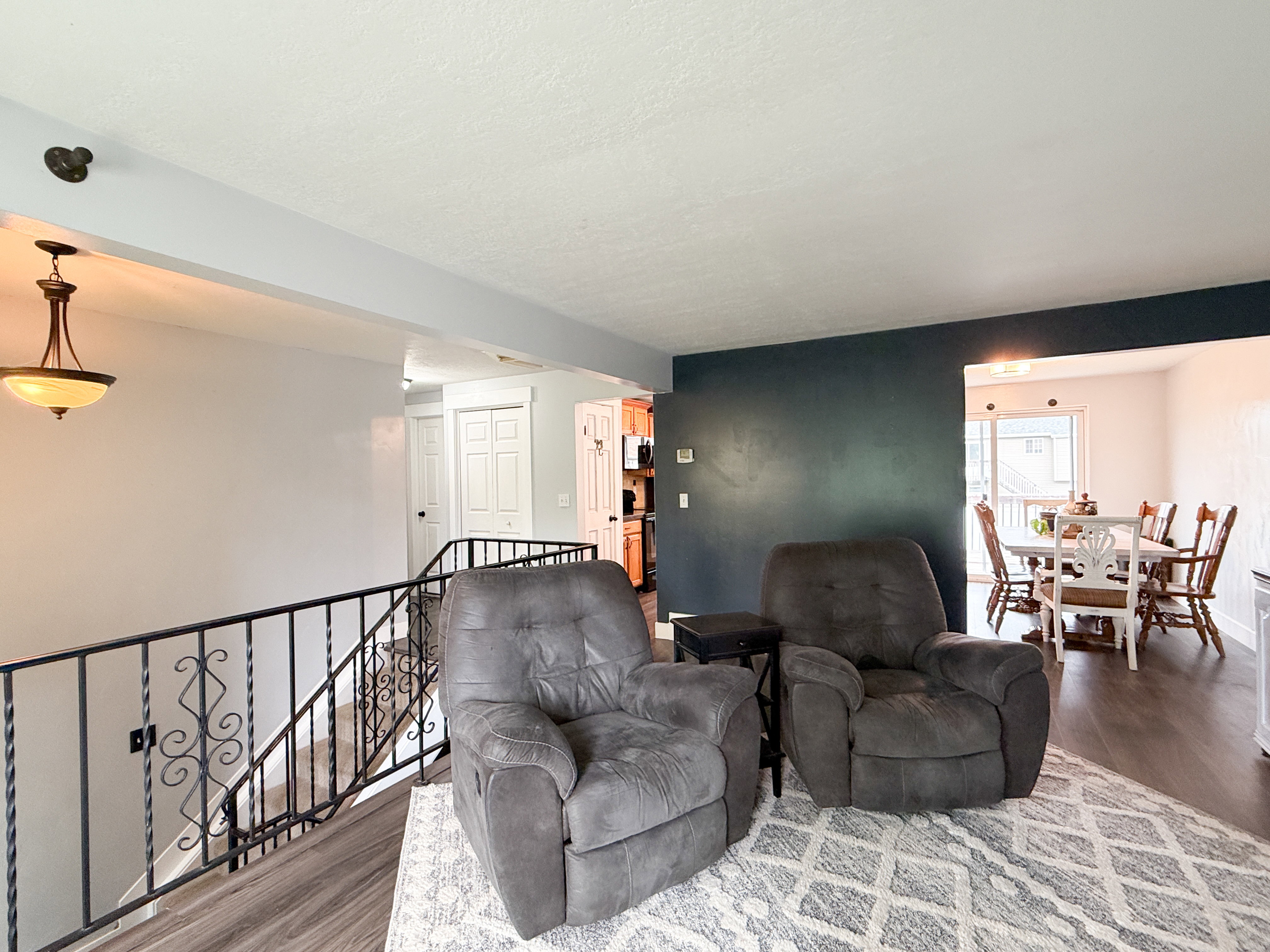 Open-concept living area featuring wood-finish flooring and a dark accent wall