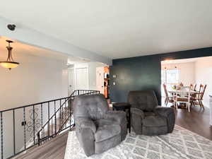 Open-concept living area featuring wood-finish flooring and a dark accent wall