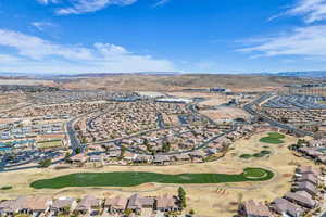 Aerial view of residential area with a golf course and a mountainous background