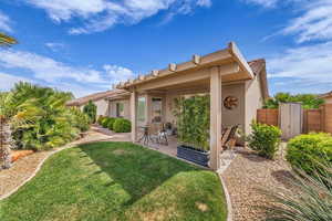 Rear view of house with a patio area, stucco siding, and a yard