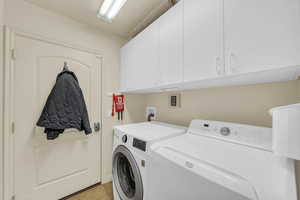 Laundry area with washing machine and clothes dryer and cabinet space