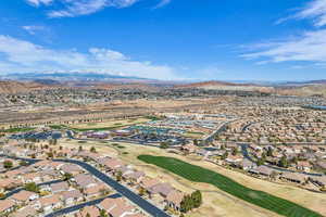 Aerial perspective of suburban area with a mountainous background and a local golf course