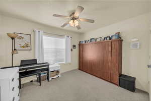 Office space featuring light carpet and a ceiling fan