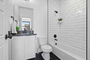 Full bathroom with vanity, shower / bath combination, and dark tile patterned flooring