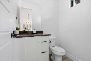 Half bath featuring vanity, a chandelier, and light wood finished floors
