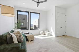 Sitting room with ceiling fan, light finished floors, and recessed lighting and big windows that let in natural light.