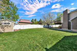 Fenced backyard with a gate, a patio, and a shed