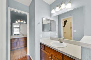 Full bathroom featuring two vanities and a spacious closet