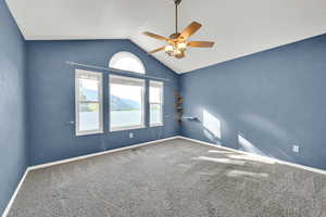 Carpeted spare room featuring baseboards and a ceiling fan