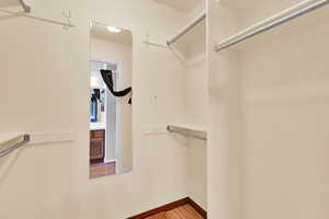 Walk in closet with light wood-type flooring