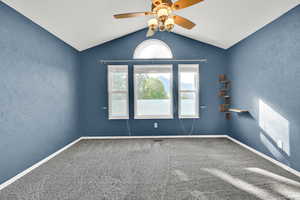 Empty room featuring a textured wall, ceiling fan, and carpet
