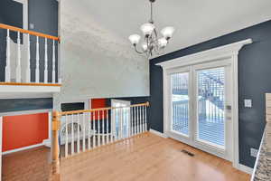 Unfurnished dining area featuring hanging lights, light wood-type flooring, and an accent wall