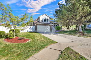 View of front of home featuring brick siding, concrete driveway, solar panels, and a garage