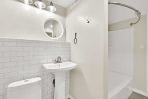 Full bath with tub / shower combination and tile walls