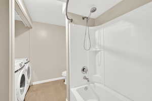 Full bath featuring shower / washtub combination and washing machine and clothes dryer