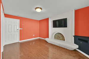 Unfurnished living room featuring wood finished floors and a fireplace