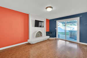 Unfurnished living room with wood finished floors, a textured ceiling, and a fireplace