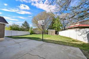 Fenced backyard with a shed and a patio