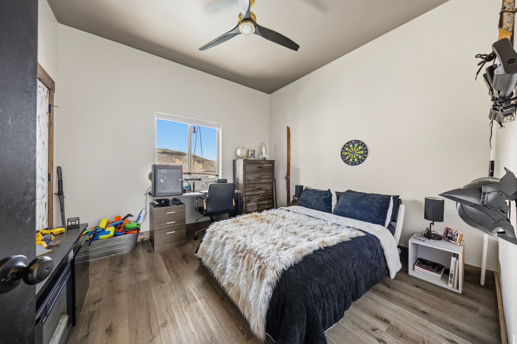 Bedroom with wood finished floors, ceiling fan, and vaulted ceiling