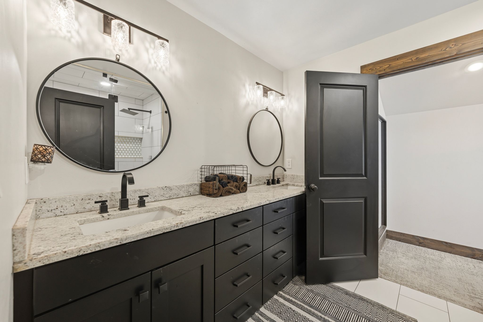 Full bathroom featuring double vanity, a shower stall, and light tile patterned floors