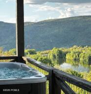 Balcony with a water view and a hot tub