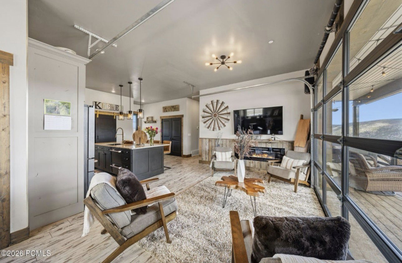 Living room with a glass covered fireplace and light wood-style flooring