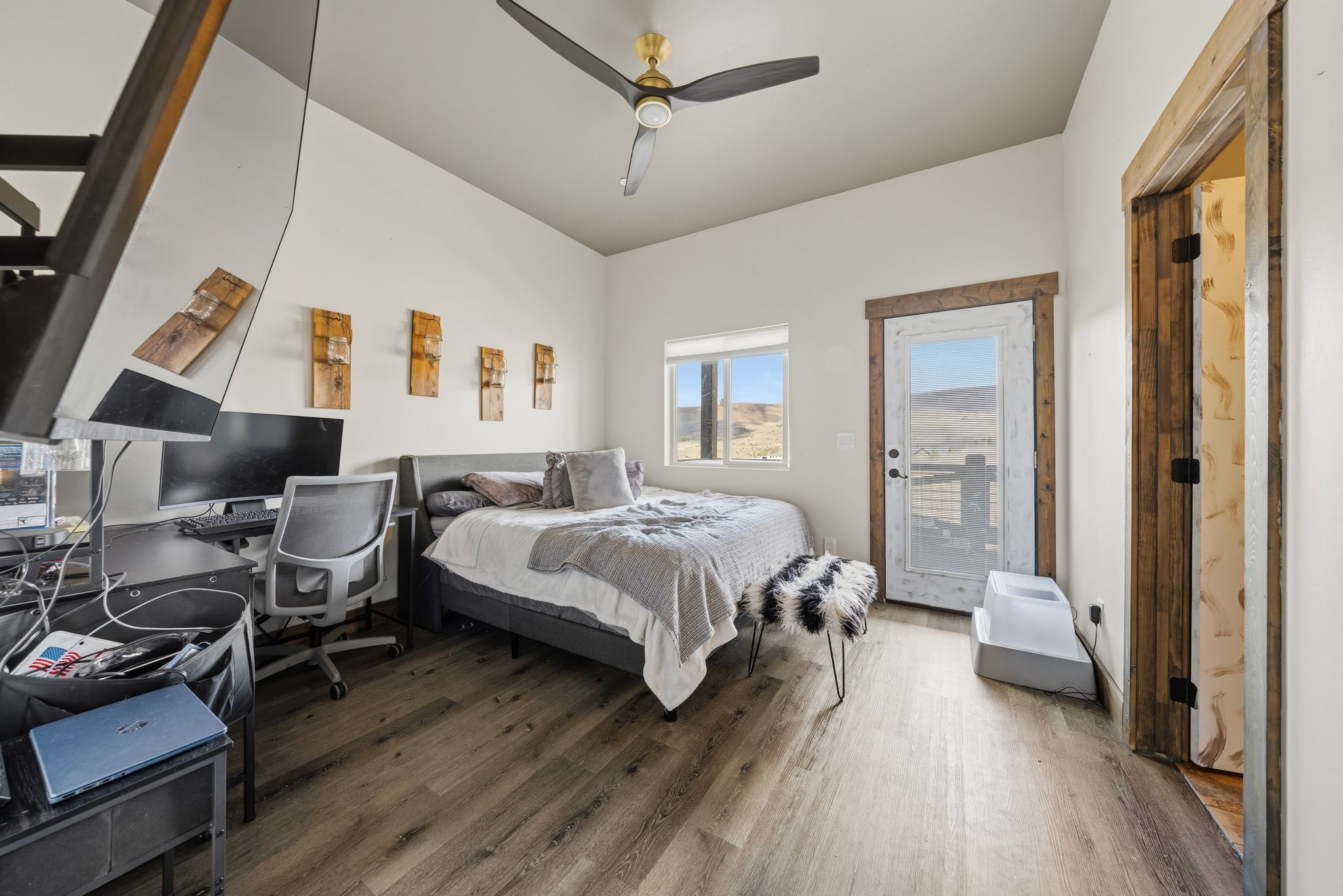 Bedroom featuring access to exterior, wood finished floors, a desk, and a ceiling fan