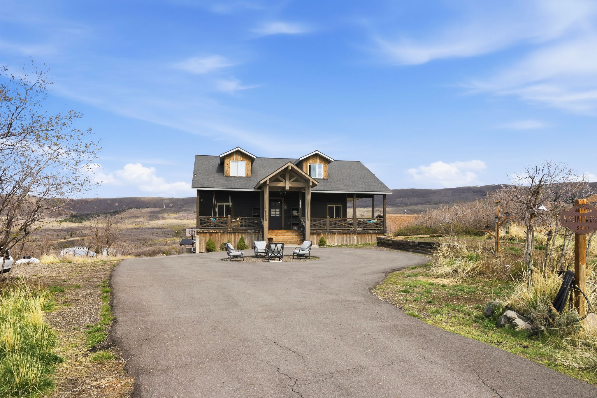 View of front of house featuring driveway, a shingled roof, and covered porch