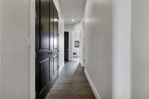 Corridor featuring wood tiled floors and recessed lighting