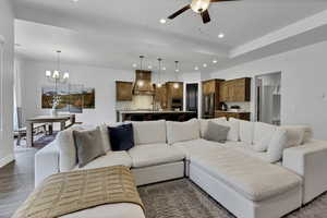Living room featuring ceiling fan, wood finish floors, and hanging lights