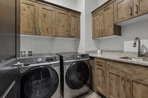 Laundry area featuring separate washer and dryer and cabinet space