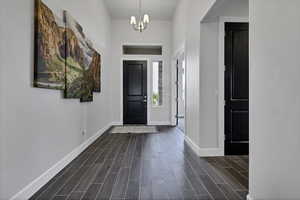 Foyer featuring wood tiled floors and a chandelier