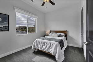 Bedroom featuring ceiling fan and dark colored carpet
