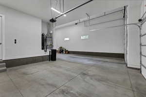 Garage featuring strapped water heater and a garage door opener