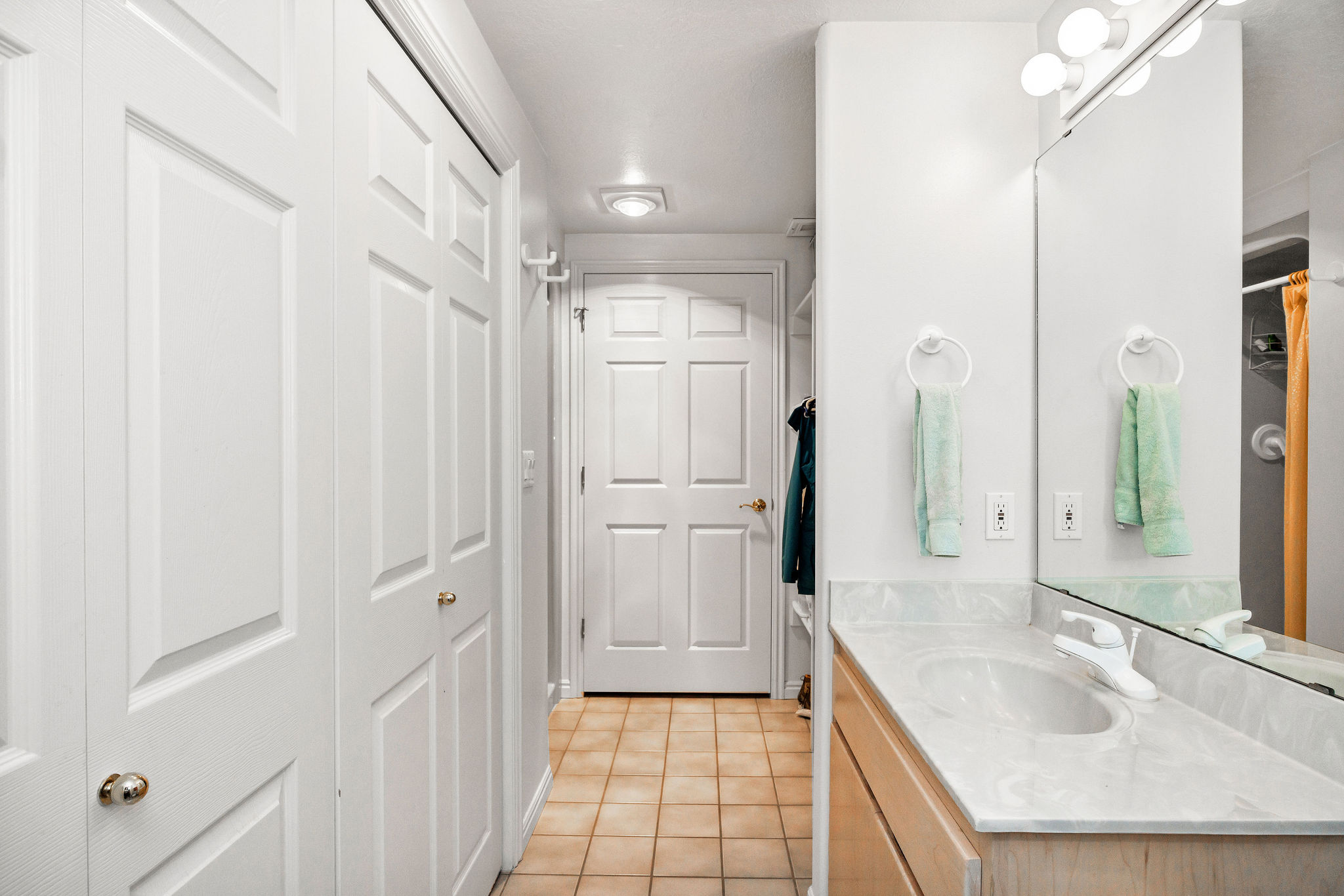 Bathroom with vanity, light tile patterned floors, and a closet