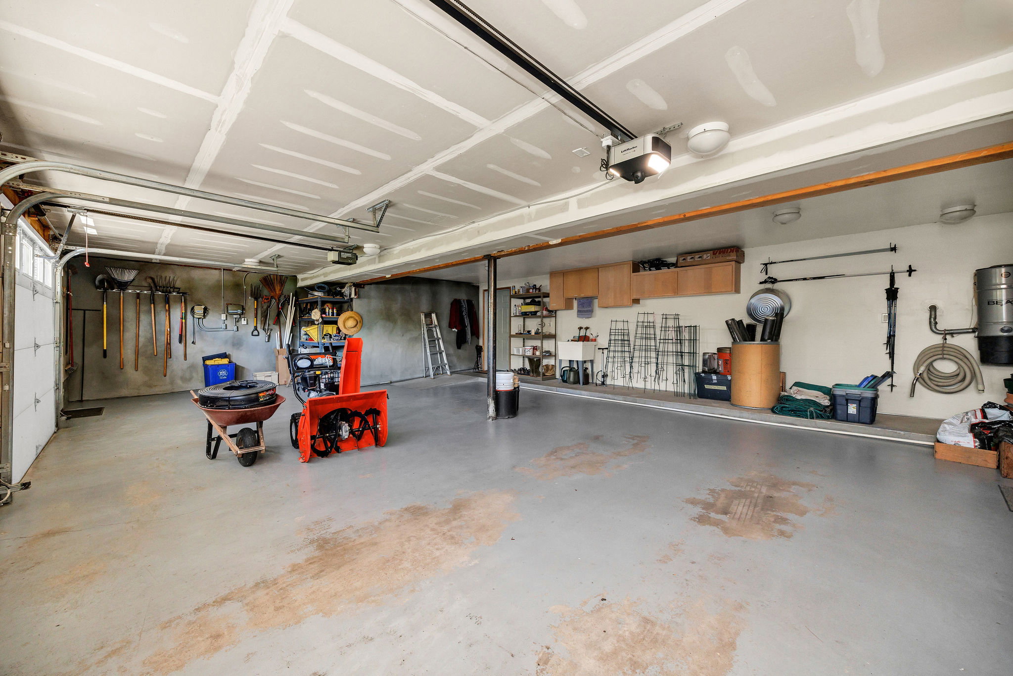 Garage with a garage door opener and a central vacuum unit