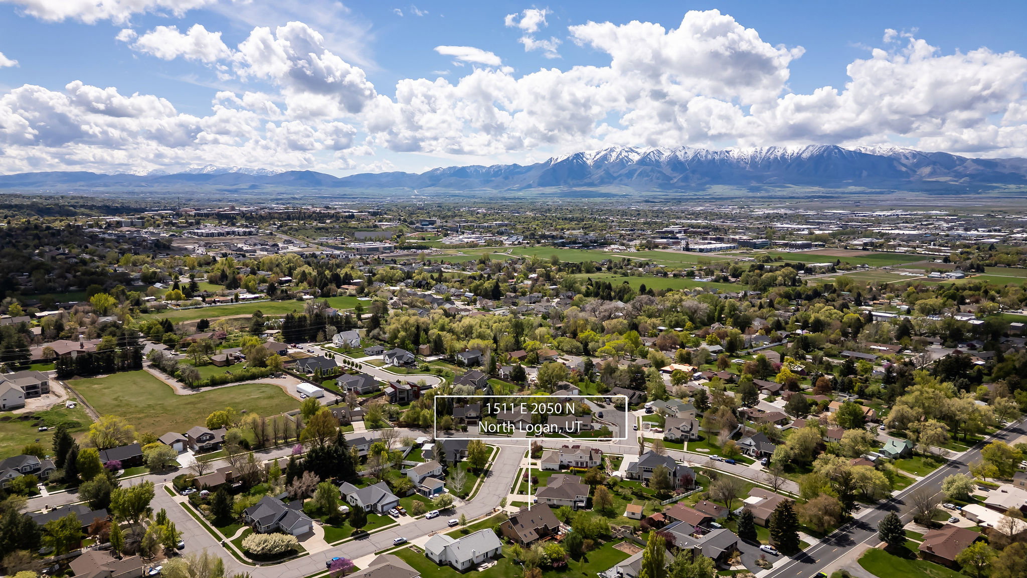 Aerial view of residential area with a mountainous background and property parcel outlined