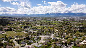Aerial view of residential area with a mountainous background and property parcel outlined