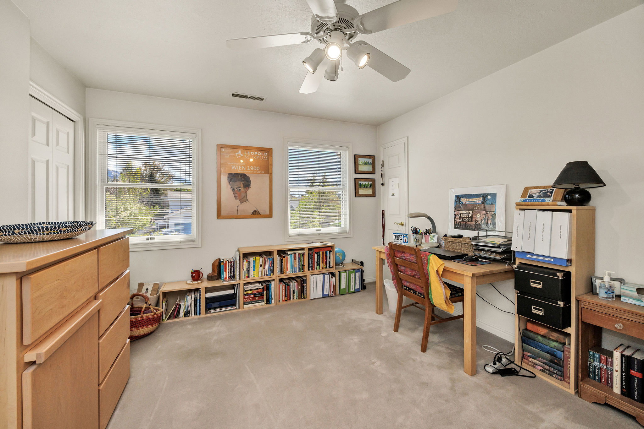Office / bedroom with light carpet and a ceiling fan