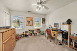 Office / bedroom with light carpet and a ceiling fan