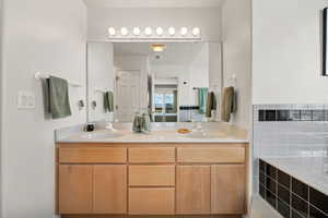 Full bath featuring double vanity and a jacuzzi bath