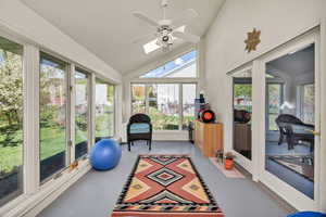 Solarium with finished concrete floors, vaulted ceiling, and a skylight