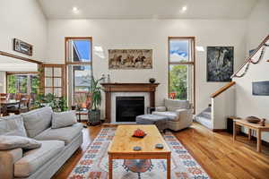 Living area featuring hardwood / wood-style flooring, a glass covered fireplace, recessed lighting, and healthy amount of natural light