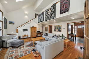Living room featuring wood finished floors, lofted ceiling, and rail lighting
