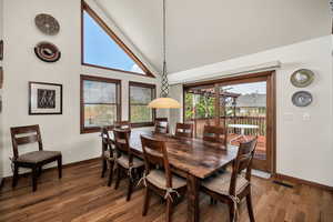 Dining space with hardwood / wood-style floors and vaulted ceiling