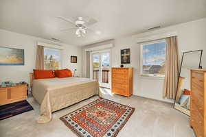Bedroom featuring access to outside, light carpet, and ceiling fan
